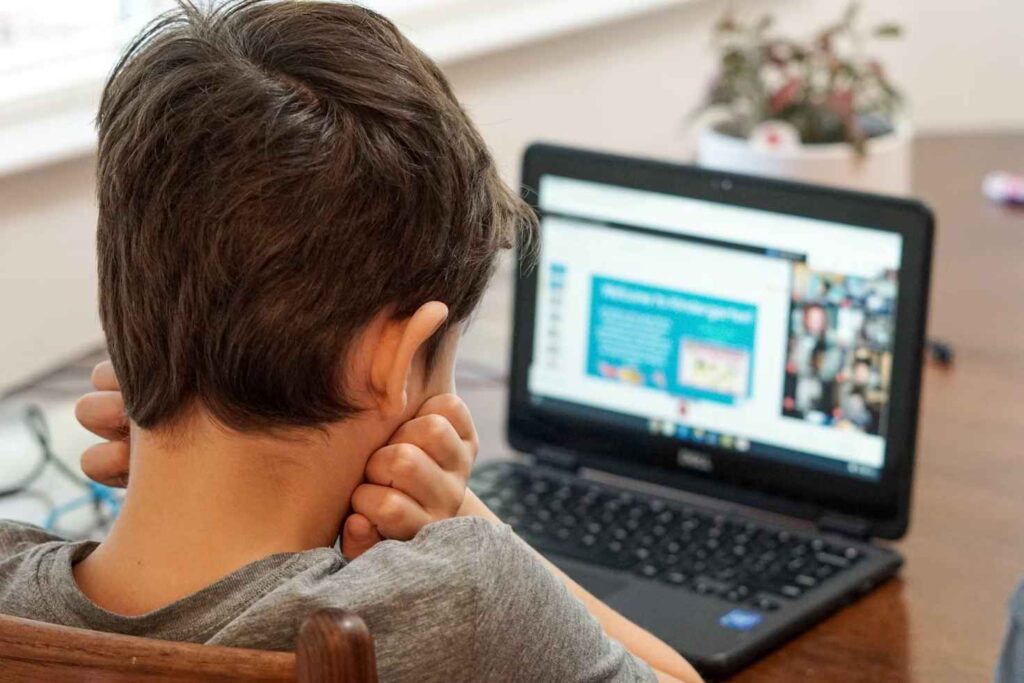 Young man looking at a computer, very frustrated.